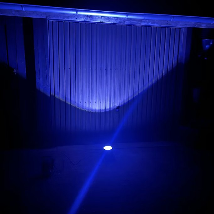 Bodenleuchte strahlt eine Wand blau an