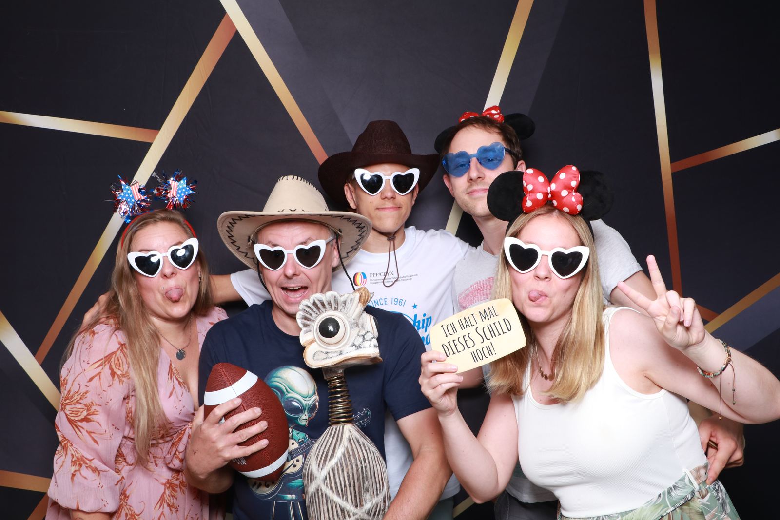 Vrienden met hartjesbrillen, cowboyhoed en muizenoren in de photobooth