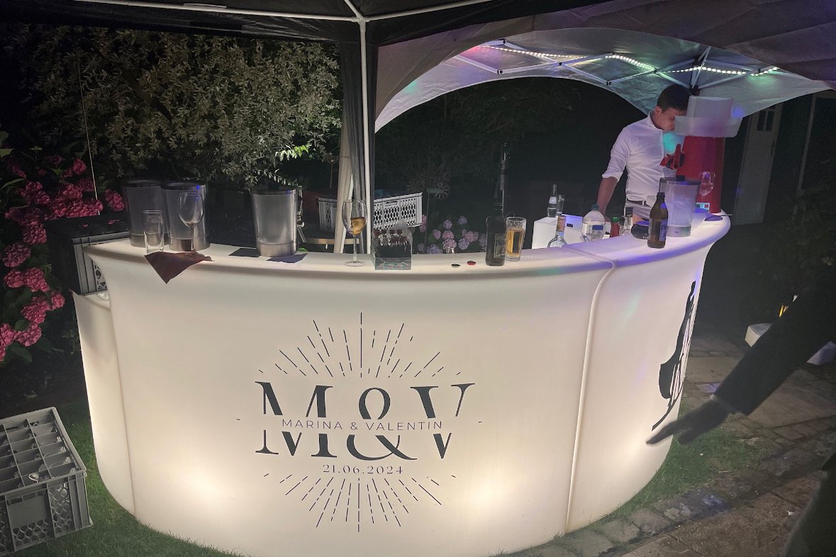 Beleuchtete LED-Bar im Garten, bedruckt mit den Initialen des Brautpaars