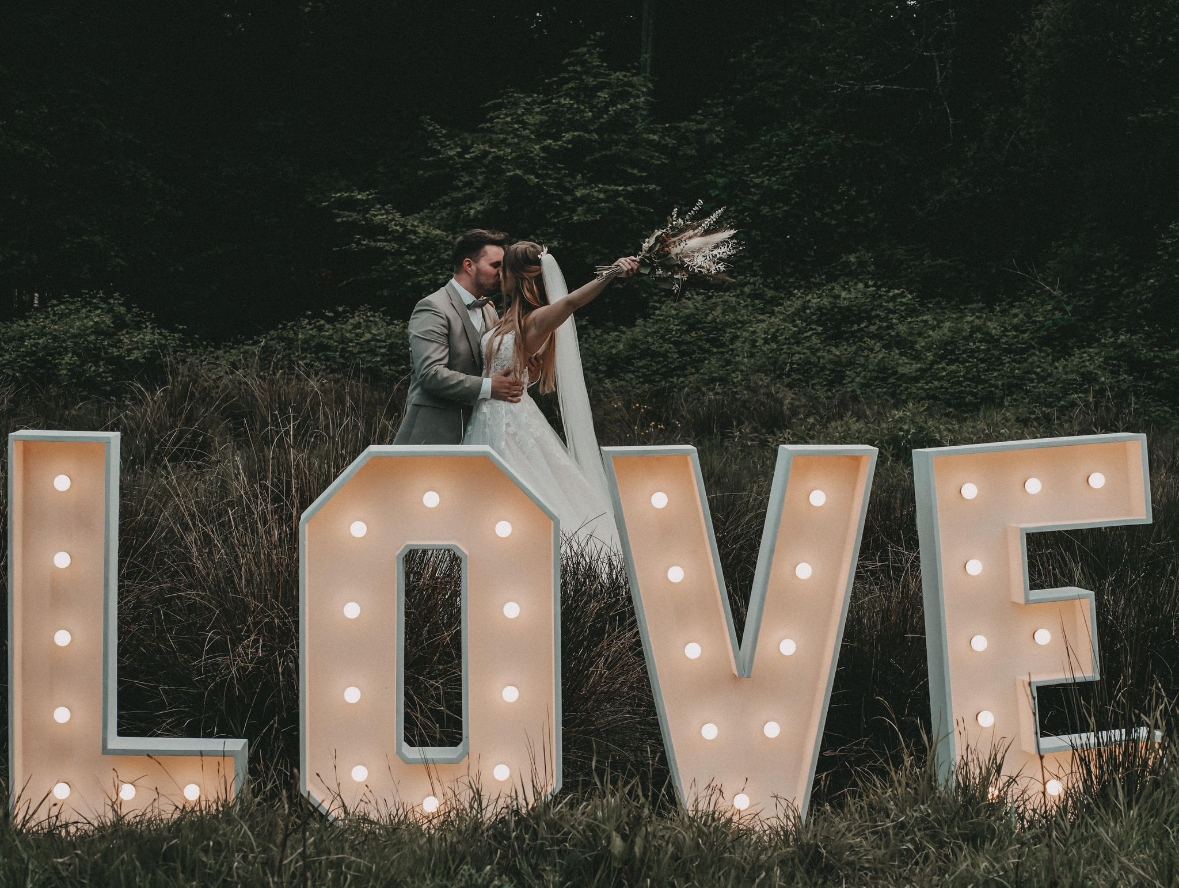 Brautpaar hinter den leuchtenden LOVE-Buchstaben
