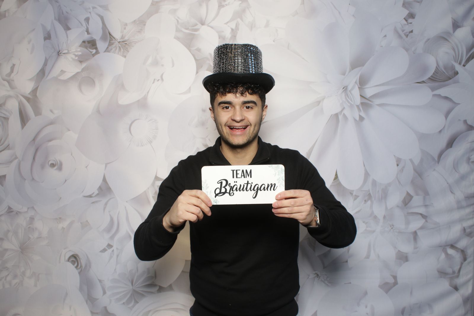 Manuel Overbeeke met hoge hoed en Team Bruidegom-bordje voor de photobooth
