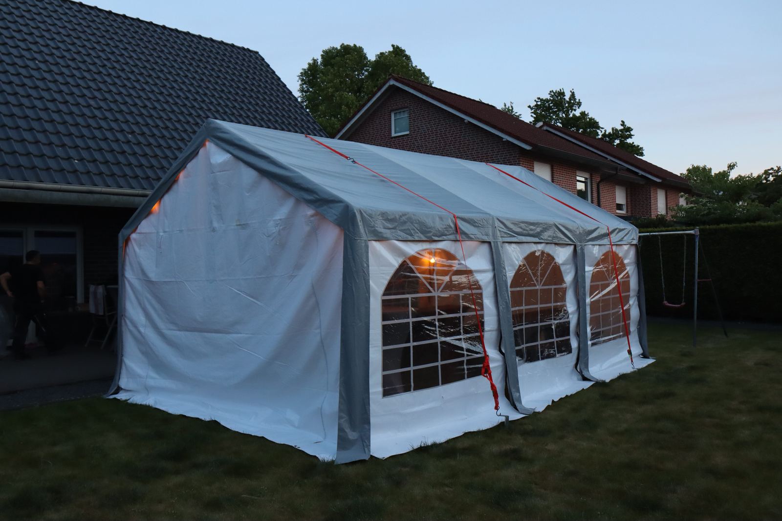 Partyzelt 4 x 6 m am Abend im Garten, Fenster warm beleuchtet