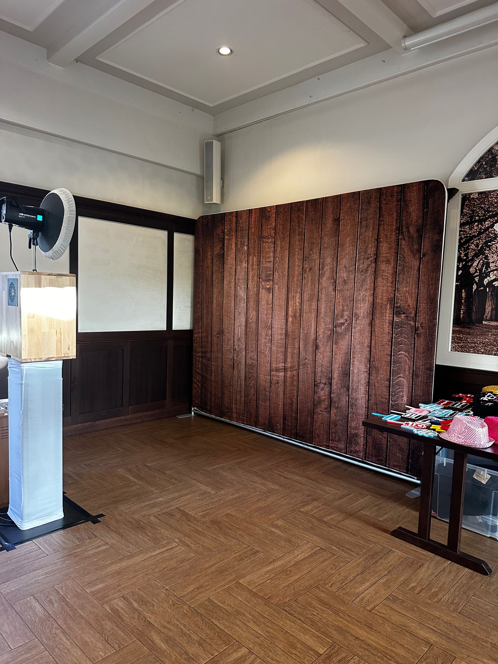 Opgebouwde photobooth voor een achtergrond met houtlook, ernaast de tafel met props